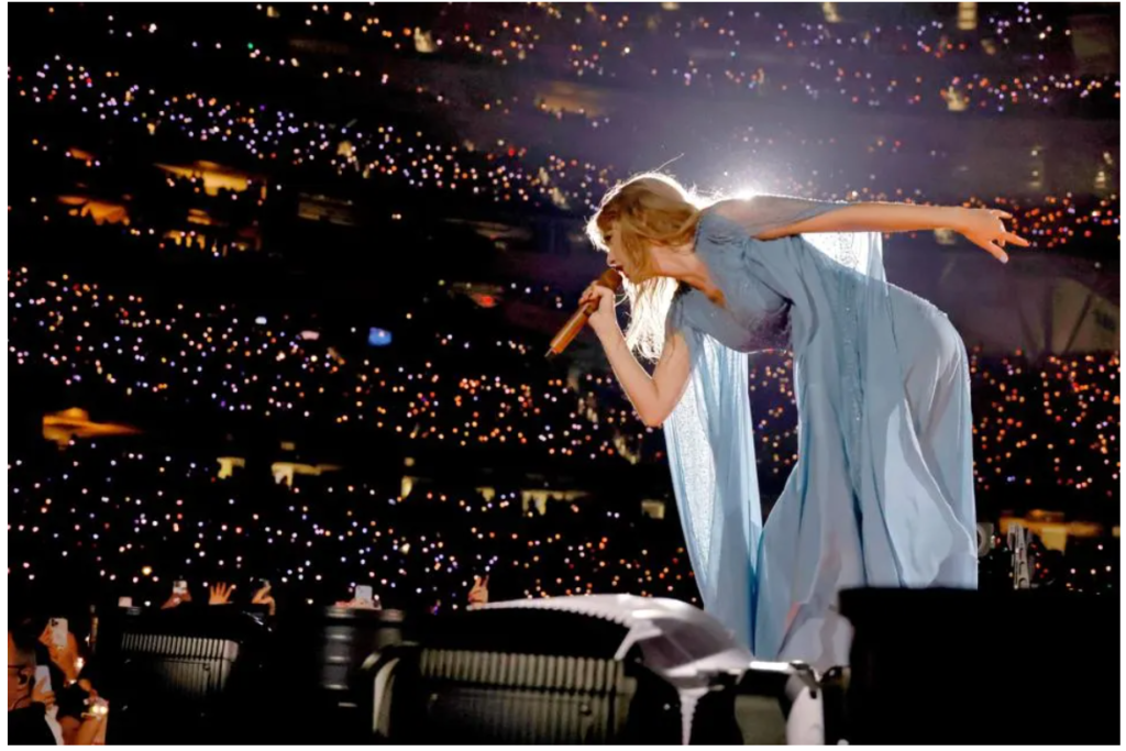 Taylor Swift performing in stadium to thousands of fans